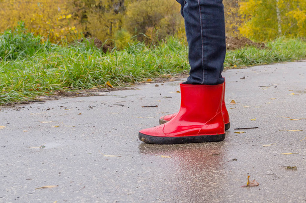 Pies en botas de goma rojas en una pista
 - Foto, Imagen