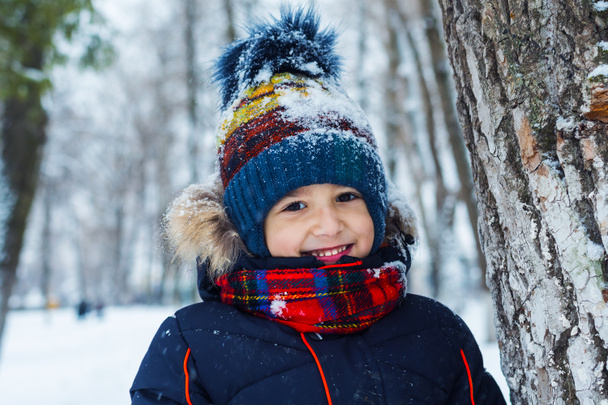 portret uśmiechniętego chłopca na tle zimowego lasu - Zdjęcie, obraz