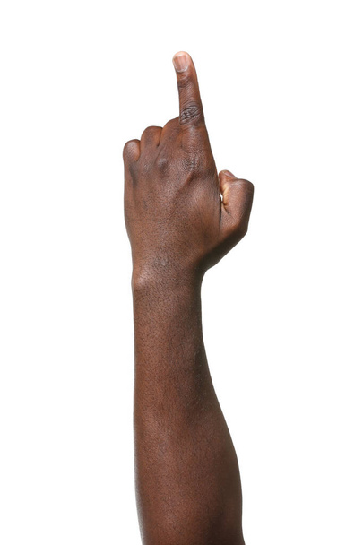 Afroamerikkalaisen miehen käsi osoittaa jotain valkoisella taustalla.
 - Valokuva, kuva