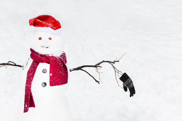 смішний сніговик в Санта шарфі і капелюсі на сніжному фоні
 - Фото, зображення