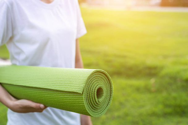 Jolie asiatique tenant tapis de yoga vert et se préparer à faire du yoga e
 - Photo, image