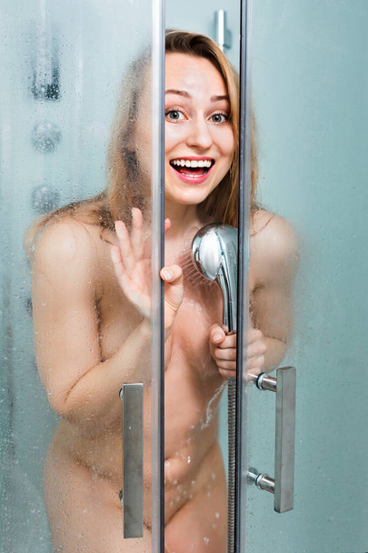 Naked woman with long blond hair taking shower - Fotó, kép