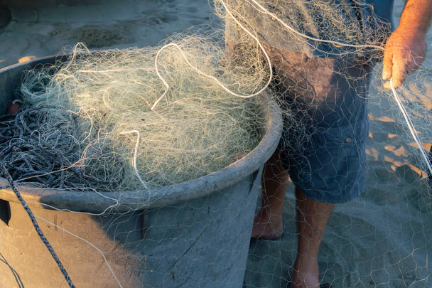 Розв'язування мережі. Рибалки тягнуть і відновлюють традиційні рибальські сітки вручну
 - Фото, зображення