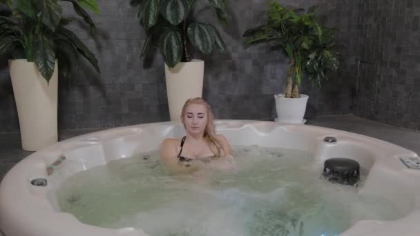 Beautiful young girl relaxes in a jacuzzi. - Footage, Video