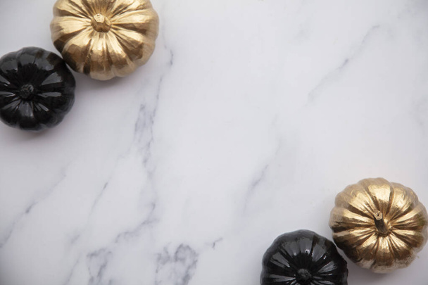 Luxury gold and black autumn pumpkin flat lay composition on a marble background - Fotoğraf, Görsel