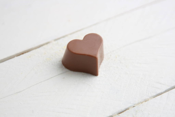 Chocolate bonbon with heart shape on white backgroun - Valokuva, kuva