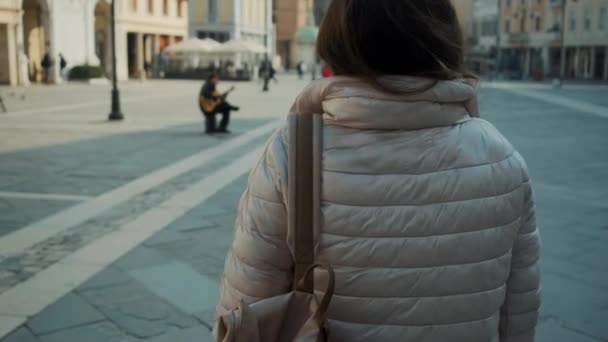 tmavovlasá dáma kráčí podél velkého náměstí - Záběry, video