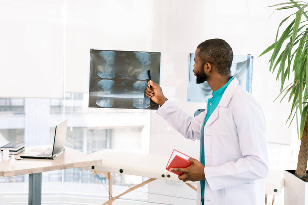 Röntgenli Afro-Amerikan sağlık çalışanı. Radyografiye bakan bir doktorun portresi - Fotoğraf, Görsel