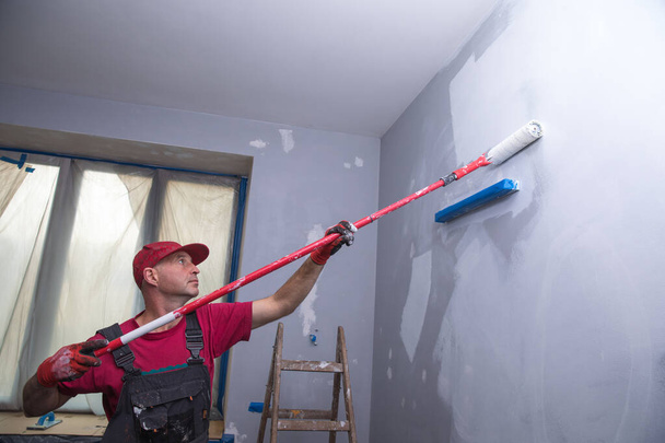 House Painting Business, Handelaar schilderen van een muur - Foto, afbeelding