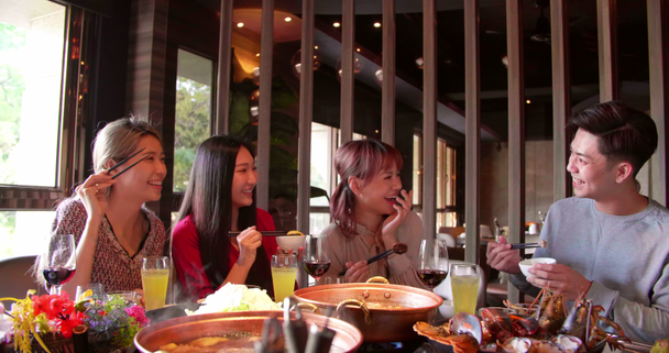 ευτυχισμένοι νέοι φίλοι απολαμβάνουν το δείπνο στο εστιατόριο ζεστό pot  - Πλάνα, βίντεο