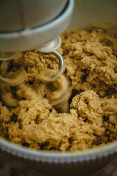 donker gember koekjesdeeg mengt in de mixer, close-up - Foto, afbeelding