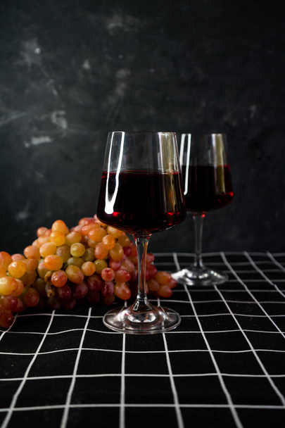 bicchieri di vino rosso con un grappolo di uva rosa
 - Foto, immagini