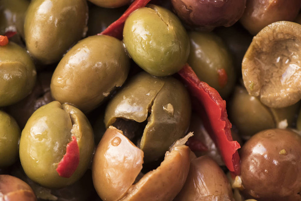 Olive spaccate e disossate fatte in casa, fatte in casa, condite nello stile tradizionale della rdoba mediterranea del sud con aglio, peperoni rossi secchi, origano, sale e aceto
 - Foto, immagini