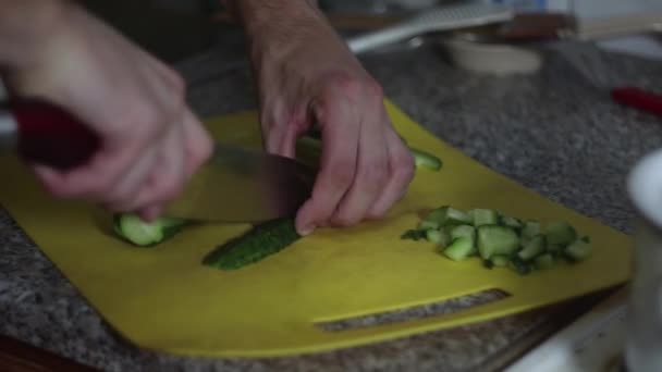 Cook cuts cucumbers in the kitchen - Felvétel, videó