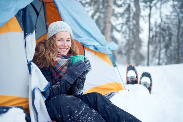 Confident solo woman traveller camping through an evergreen winter forest in Canada - 写真・画像