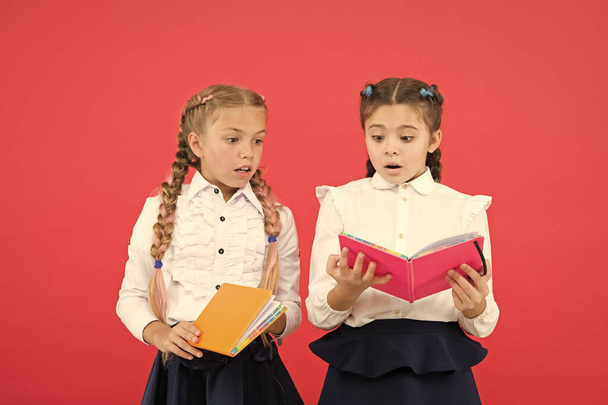 Lesen öffnet Türen. kleine Kinder lesen Bücher auf rotem Hintergrund. entzückende kleine Mädchen lernen in der Schule lesen. Niedliche Schüler lesen, um wichtige Informationen zu lernen - Foto, Bild