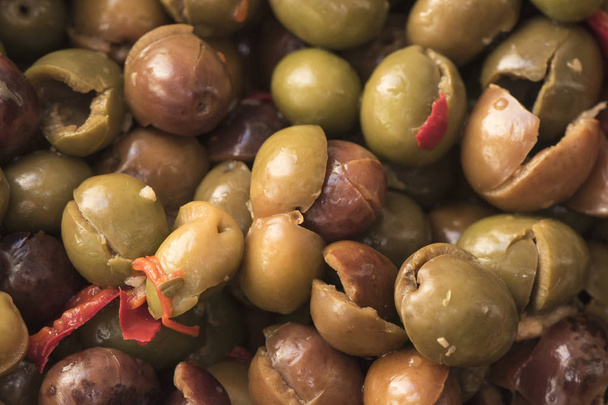 Olive spaccate e disossate fatte in casa condite nello stile tradizionale della Cordova meridionale con peperoni rossi secchi all'aglio, origano, sale e aceto
 - Foto, immagini