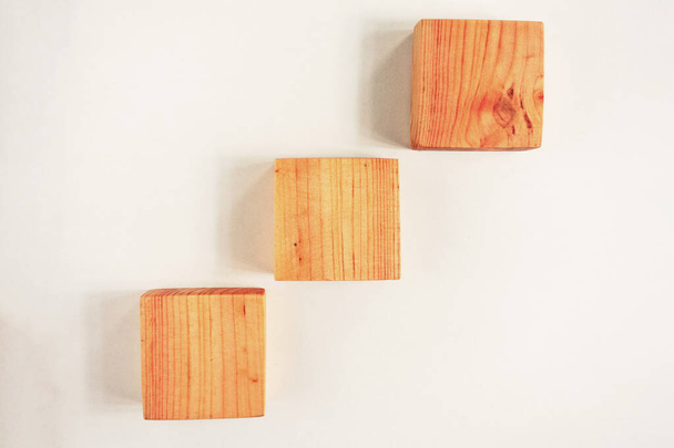 Drewniane kwadratowe kawałki prętów z cieniami na białym tle. Wspinaczka - Zdjęcie, obraz