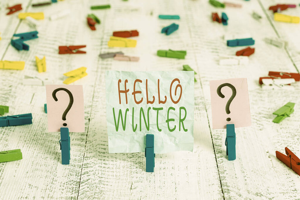 Conceptual hand writing showing Hello Winter. Business photo showcasing coldest season of the year in polar and temperate zones Crumbling sheet with paper clips placed on the wooden table. - Fotoğraf, Görsel
