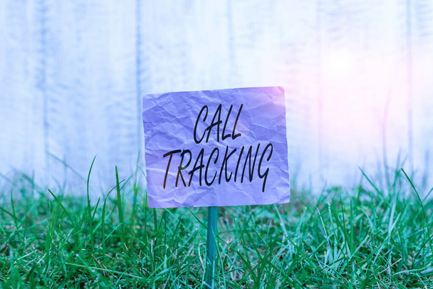 Conceptual hand writing showing Call Tracking. Business photo text Organic search engine Digital advertising Conversion indicator Plain paper attached to stick and placed in the grassy land. - Photo, Image