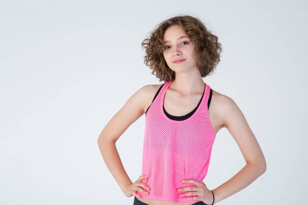 Portrait young beautiful woman with curly hair in sportswear for fitness classes. - Valokuva, kuva