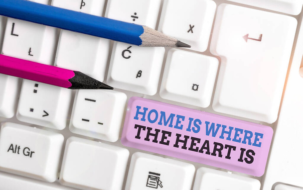 Rukopis Home Is Where The Heart Is. Koncept znamená Váš dům je místo, kde se cítíte pohodlně a šťastně Bílá PC klávesnice s prázdným poznámkovým papírem nad bílým pozadí klíč kopírovat prostor. - Fotografie, Obrázek