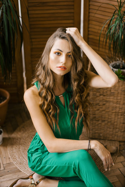 Stylish beautiful woman in green clothes holding her hand on her head - Photo, Image