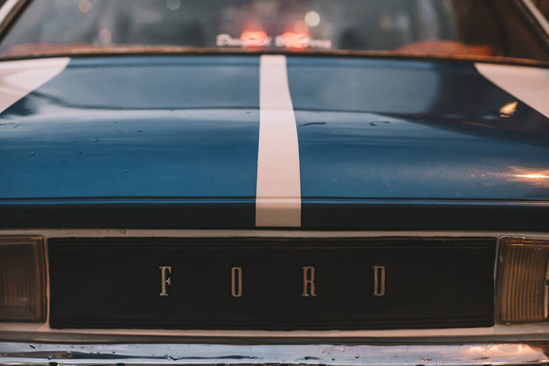 Ретро автомобиль Ford Granada с голубыми полосками на ночной улице. Вид сзади. Красивая винтажная машина. Cappfucia, Goreme, Турция 2019-08-16
 - Фото, изображение