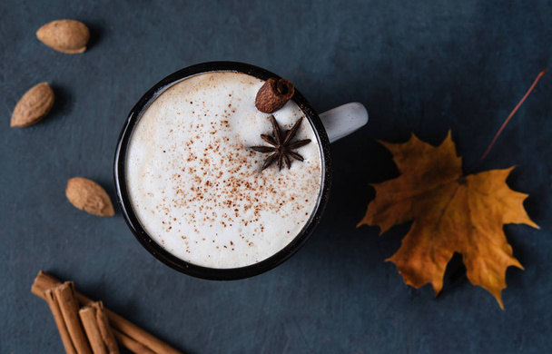 melanžové kávové latté s cinamonem a ořechem na tmavomodrém stole - Fotografie, Obrázek