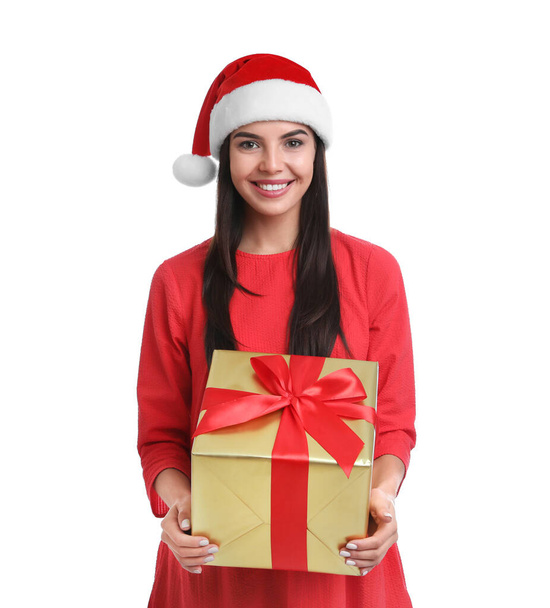 Happy young woman in Santa hat holding Christmas gift on white background - Foto, immagini
