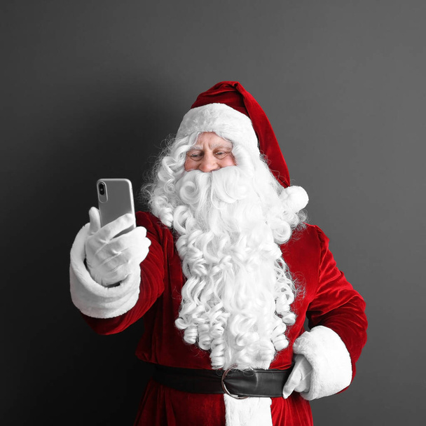 Authentic Santa Claus taking selfie on grey background - Photo, Image