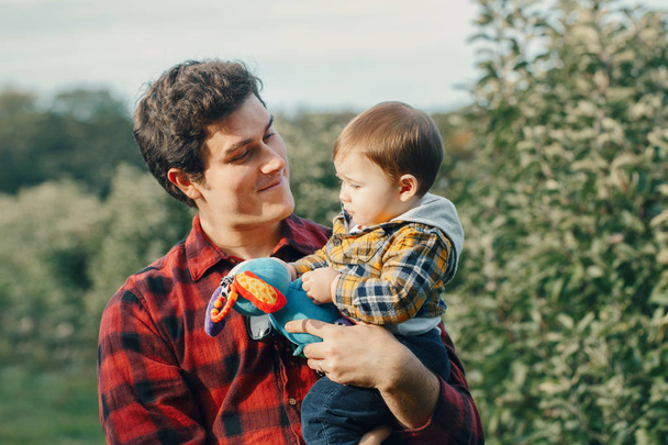 Beyaz bir babanın erkek bebekle oynaşması. Çocuğunu taşıyan bir ebeveyn. Otantik yaşam tarzı dokunaklı bir an. Bekar baba aile hayatı konsepti. Mutlu babalar. - Fotoğraf, Görsel
