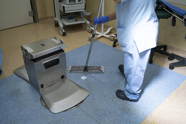 Konzeptfoto eines Arbeiters unkenntlich Reinigung im Operationssaal - Foto, Bild