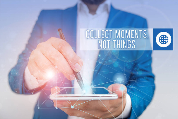 Conceptual hand writing showing Collect Moments Not Things. Business photo text Happiness philosophy enjoy simple life facts Male human wear formal suit presenting using smart device. - Fotoğraf, Görsel