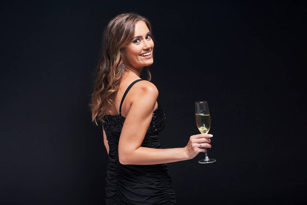 Young woman in elegant dress staying with glass of champagne aga - Фото, зображення