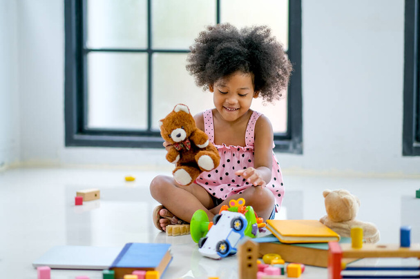 Одна молода африканська дівчина грає в іграшки, розважається і отримує задоволення.. - Фото, зображення