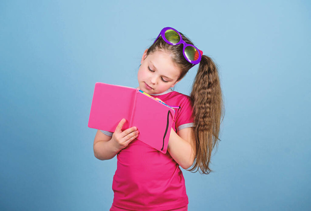 reading book. Summer fashion. small happy girl in glasses with notebook. diary notes. small beauty girl write her memories. making plans for summer holidays and vacation. schoolgirl ready for lesson - Foto, Bild