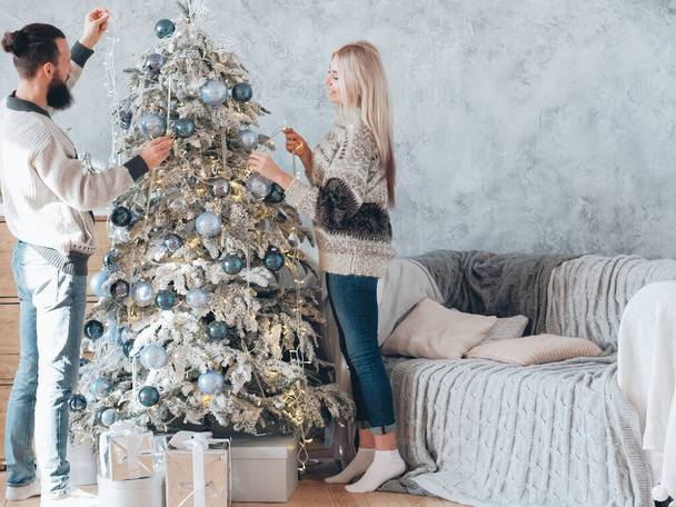 family winter holidays couple decorating fir tree - Photo, Image