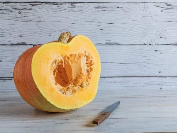 A large ripe pumpkin is cut with a knife. - Φωτογραφία, εικόνα