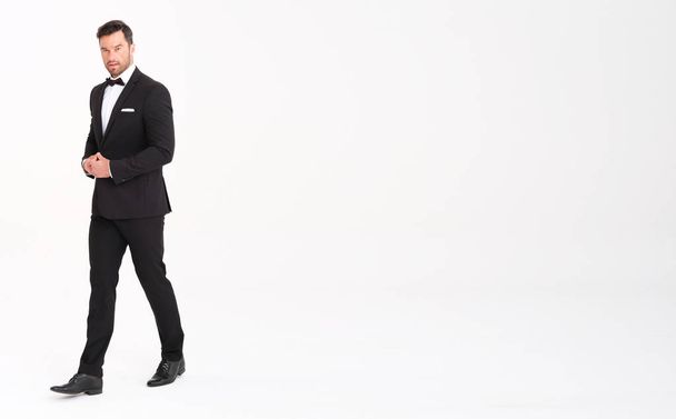 Handsome man in classic black suit looks very elegant. - Foto, Bild