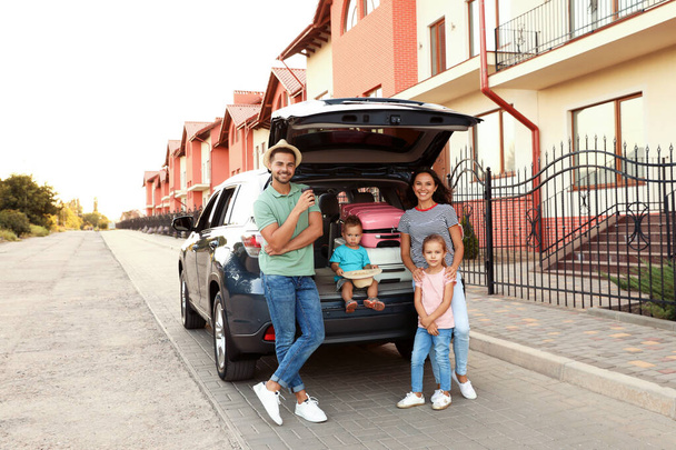 Happy family with suitcases near car in city street - Zdjęcie, obraz