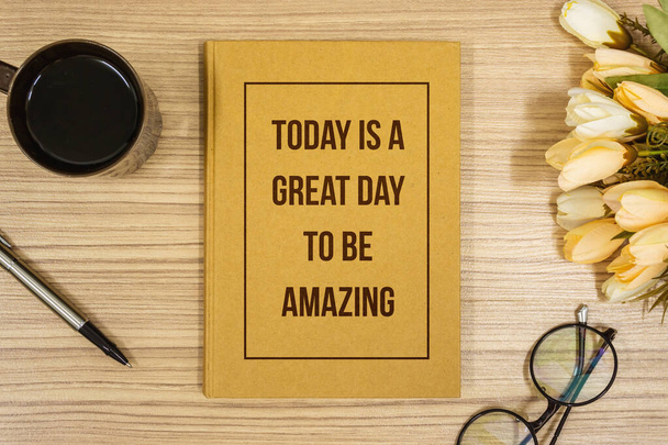 Notebook with Inspirational Quote on Wooden Work Desk. Be Amazing. - Photo, Image