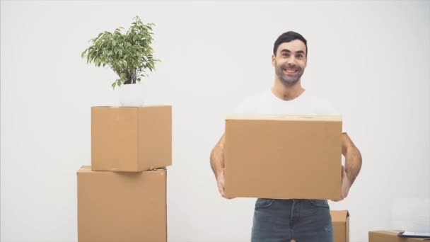 Strong and funny man is carring and dancing with a large moving box, full of items, isolated on white background. Action. Animation. 4K. - Video