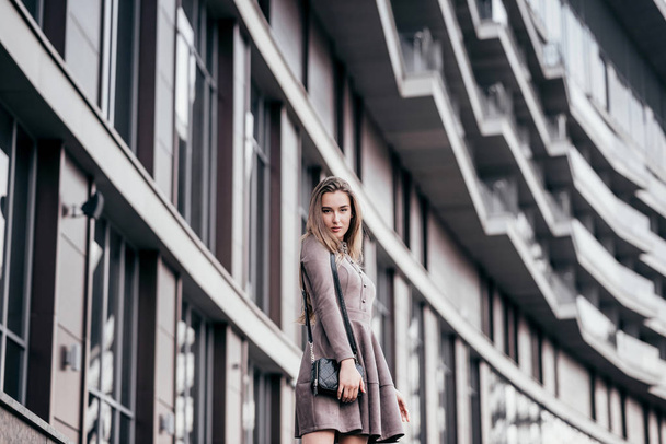 A young girl walks near the office with a handbag on her shoulder - Fotografie, Obrázek