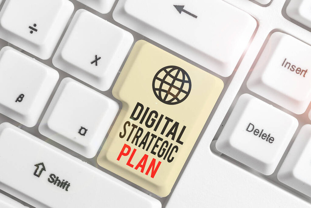 Writing note showing Digital Strategic Plan. Business photo showcasing creat schedule for marketing product or brand White pc keyboard with note paper above the white background. - Photo, Image