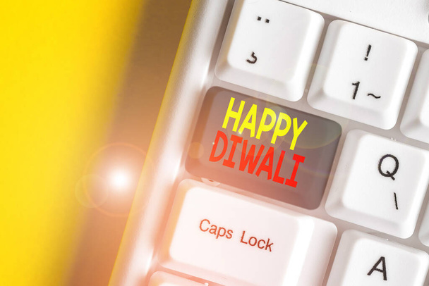 Wort schreiben Text happy diwali. Geschäftskonzept für das Lichterfest, das von Millionen Hindus gefeiert wurde, weiße PC-Tastatur mit leerem Notizpapier über weißem Hintergrund. - Foto, Bild