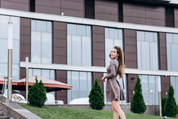 A young girl walks near the office with a handbag on her shoulder - Fotoğraf, Görsel