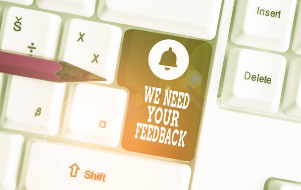 Conceptual hand writing showing We Need Your Feedback. Business photo showcasing Give us your review thoughts comments what to improve White pc keyboard with note paper above the white background. - Photo, Image