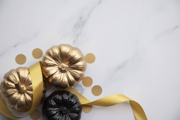 Luxury gold and black autumn pumpkin flat lay composition on a marble background - Foto, Imagem