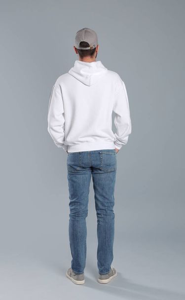 Young man in sweater on grey background. Mock up for design - Photo, image
